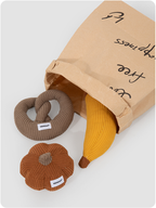 Three catnip plush toys beside a paper bag